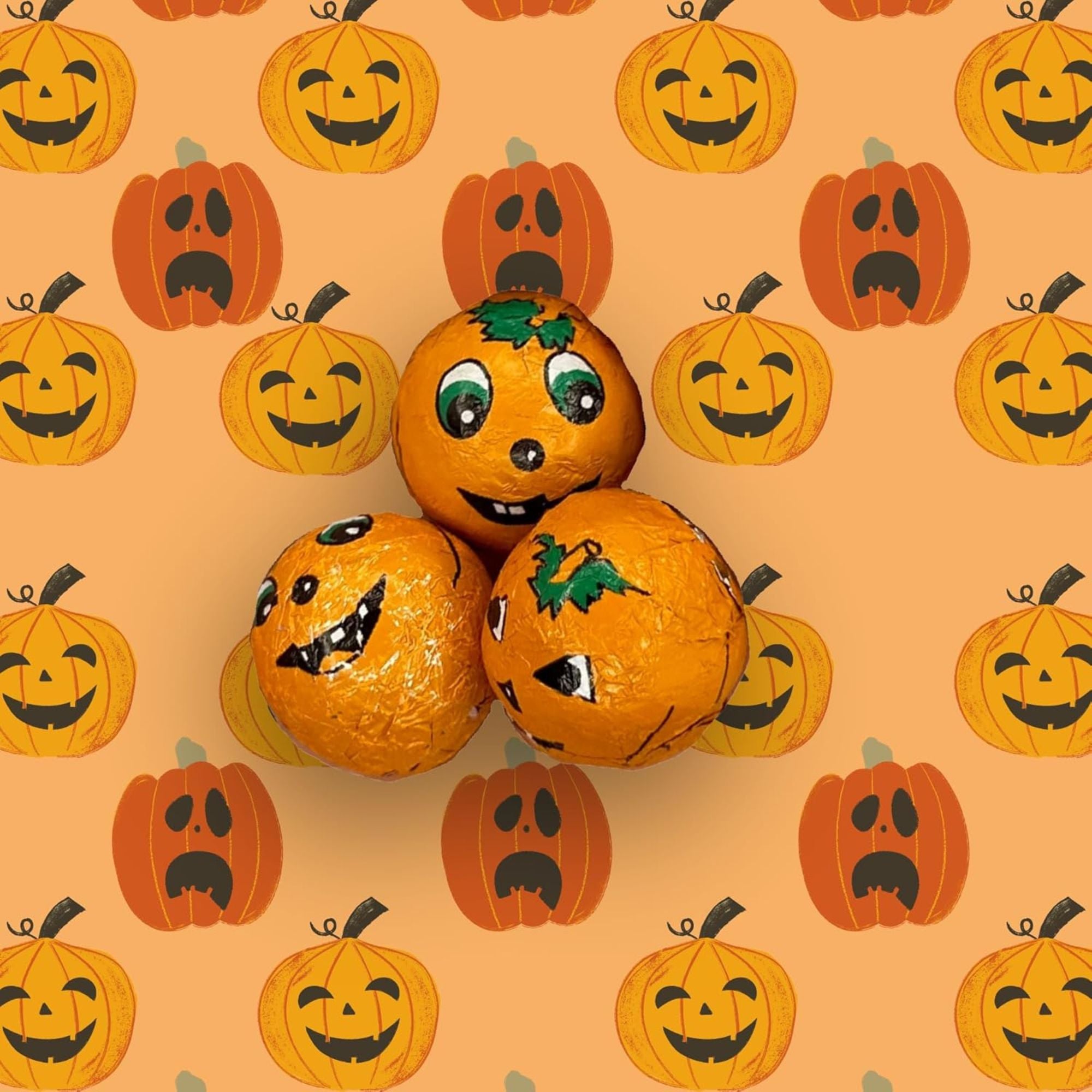 Three decorated pumpkins with faces on an orange background with pumpkin pattern