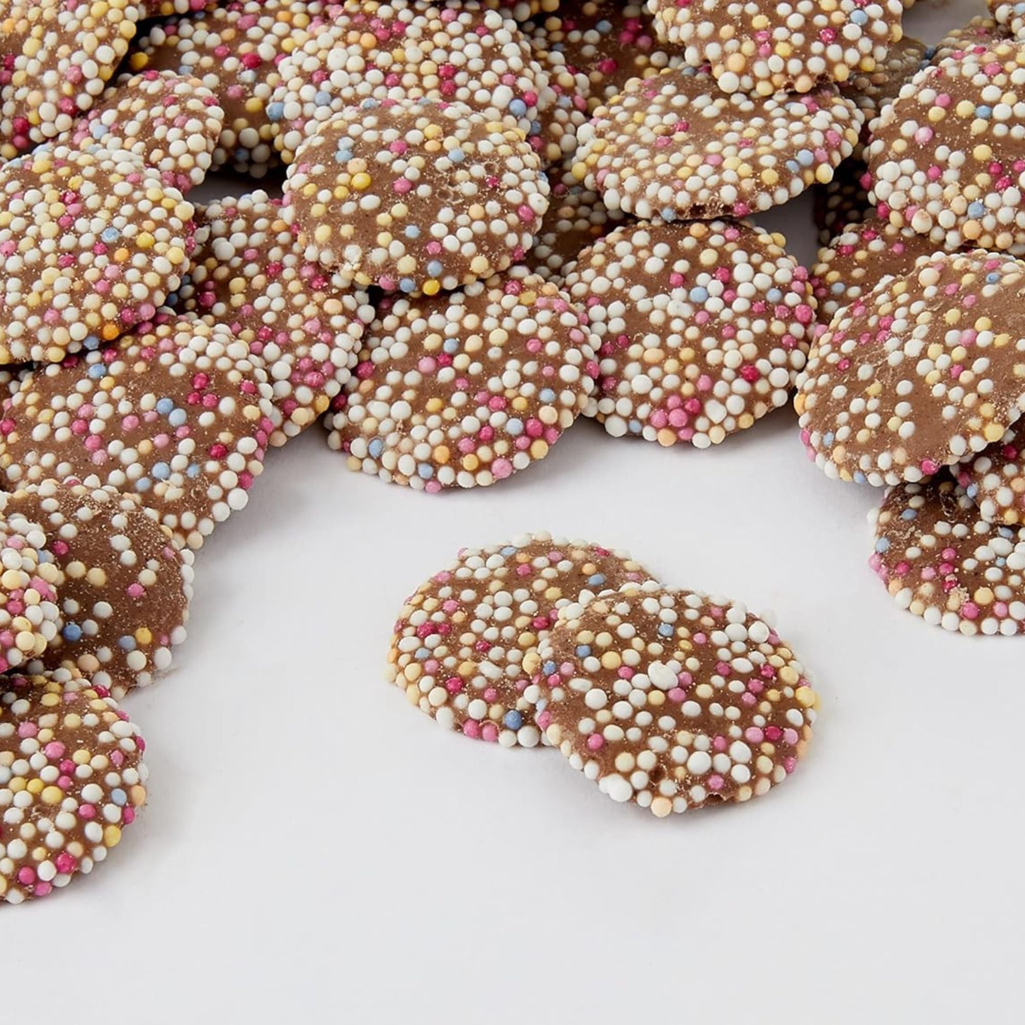 Chocolate cookies with colorful sprinkles on a white surface