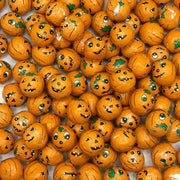 Orange pumpkin-shaped candies with faces on a white background