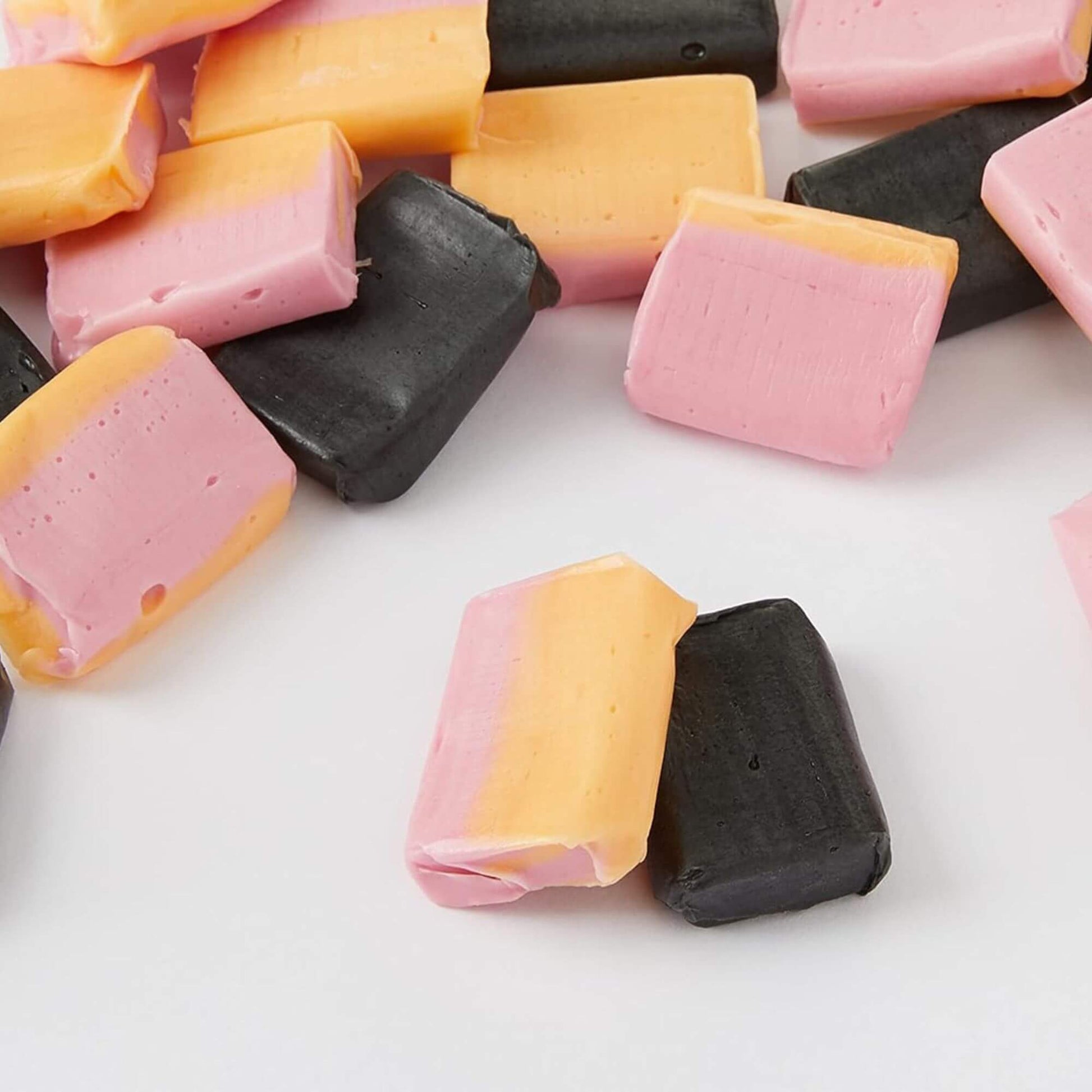 Colorful jelly candies in pink, orange, and black on a white background