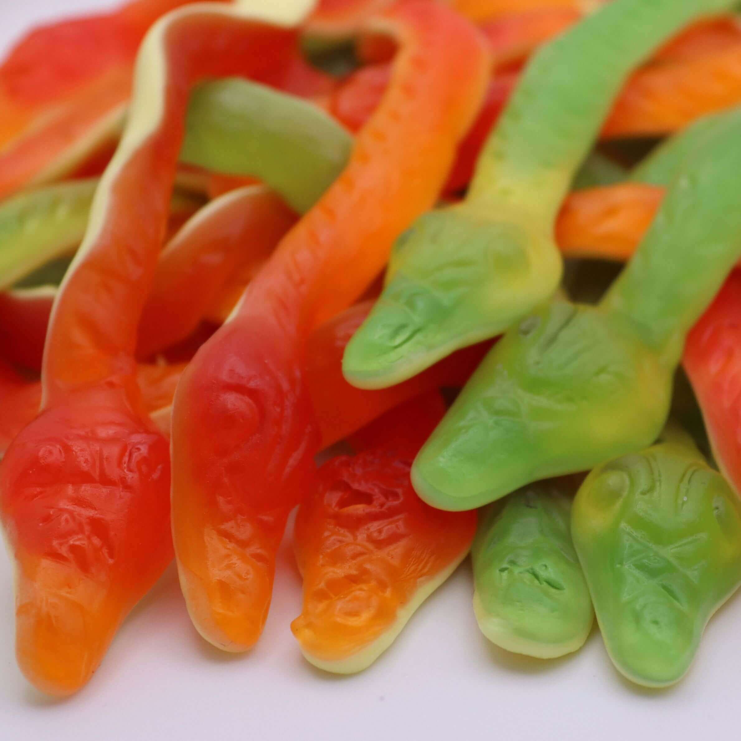 Close-up of colorful gummy worms on a white background